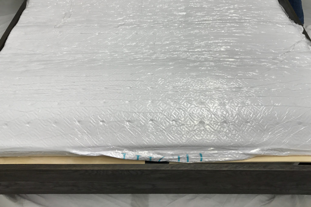 The Lucid mattress wrapped in plastic and expanding