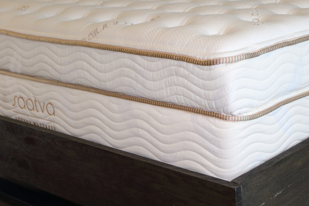 The Saatva is placed on a bed by the couriers