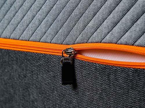 Image of the Recore mattress cover focusing on the neon orange zipper and two-tone grey fabric.