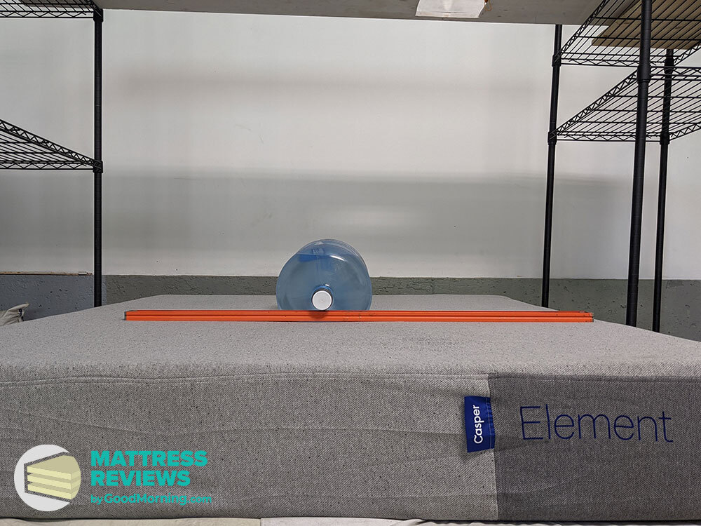 Water jug and level on Casper Element mattress to measure firmness