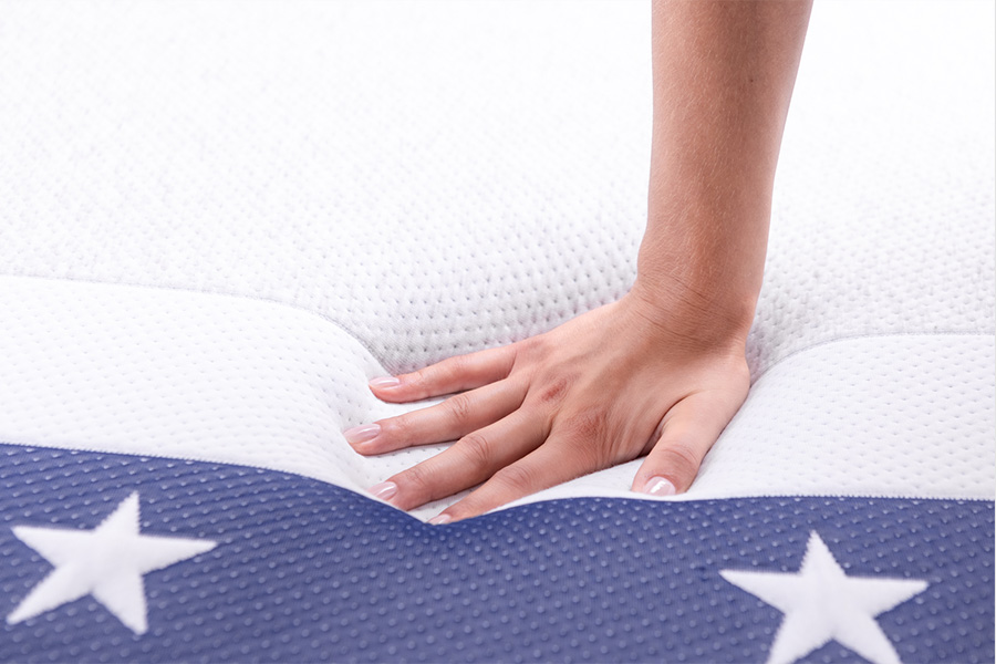 Hand pressing into the top cover of Full Moon by GoodMorning.com mattress