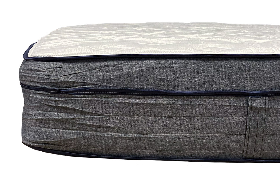 The Endy Hybrid mattress shown from the side with some wrinkles in the grey fabric cover