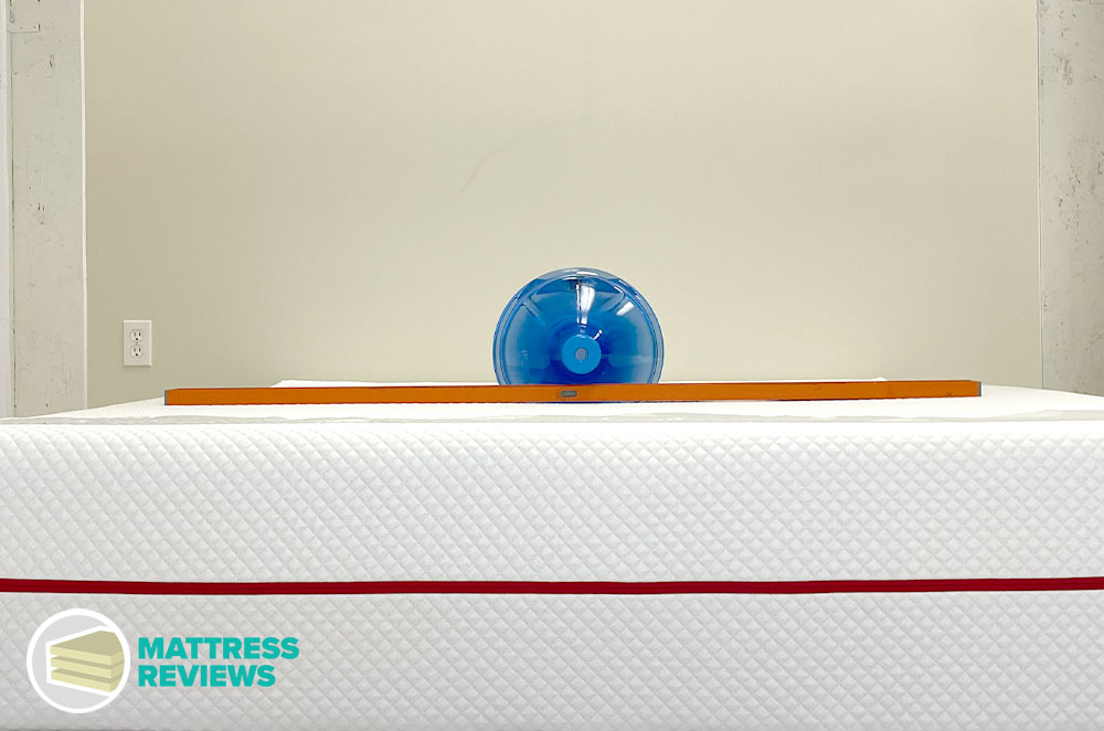 A heavy jug of water rests in the middle of the Douglas Summit mattress to measure sinkage