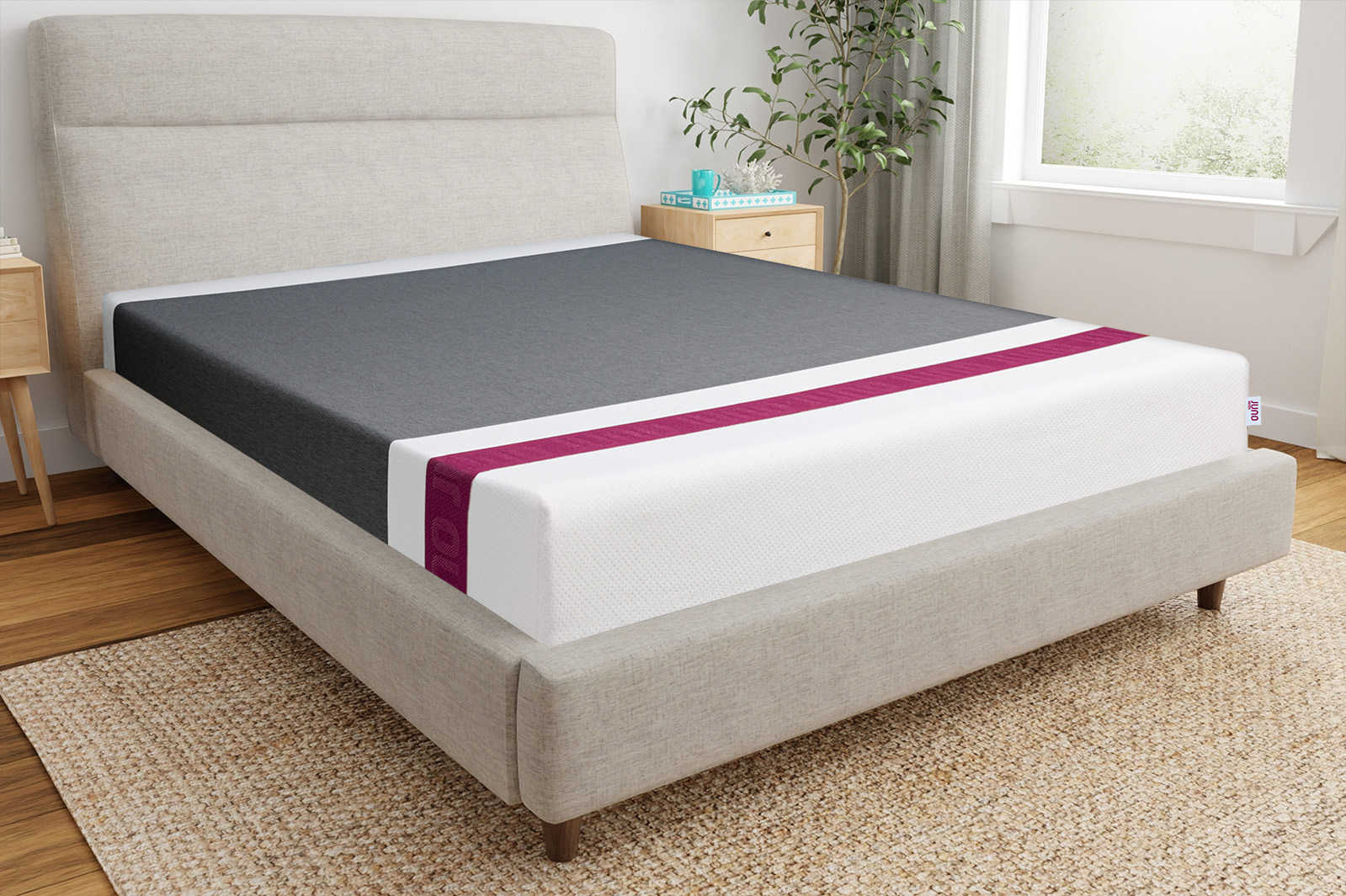 Front corner angle photo of a Juno Hybrid mattress sitting on a bedframe in a bedroom