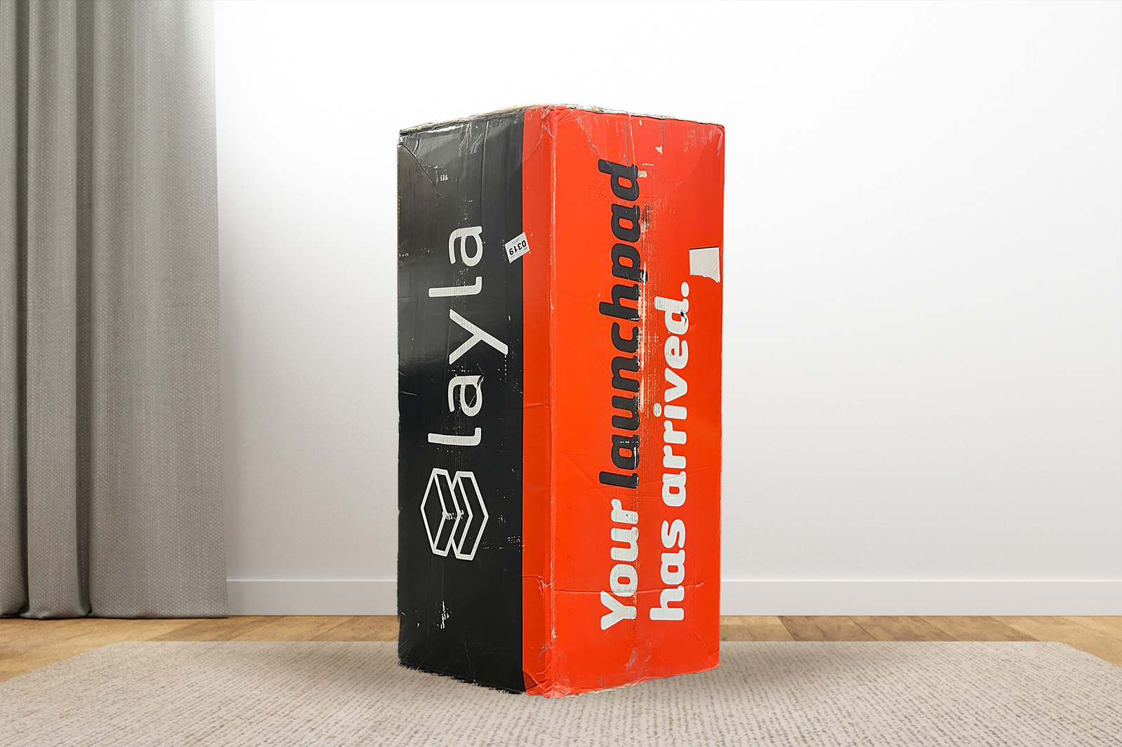 LaylaBox MattressReviewscom The Layla mattress box standing upright on a carpet in a bedroom