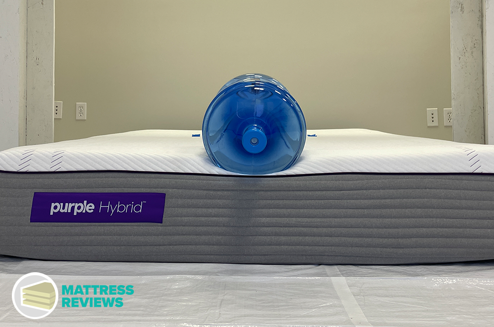 Water jug near edge of the bed for Purple Hybrid mattress engineer edge-support test