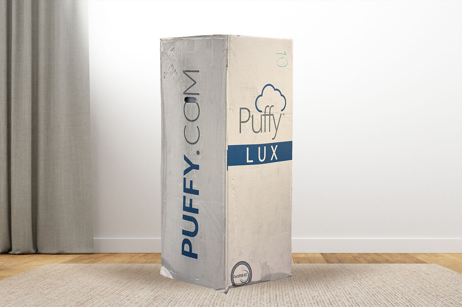 PuffyLuxBox MattressReviewscom Photo of the puffy lux mattress box on the floor in a bedroom taken from a front angle