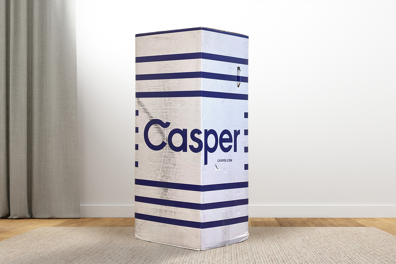 TheCasper2025Box MattressReviewscom The Casper mattress box standing upright on a carpet in a bedroom