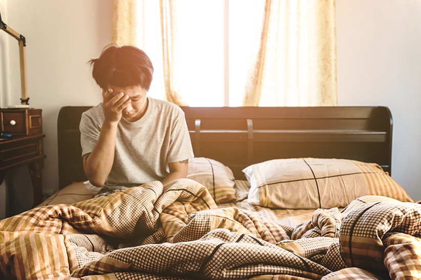 Canadians Will Pay More for Environmentally Friendly Sleep Products hero image photo of a person sitting up in bed looking tired