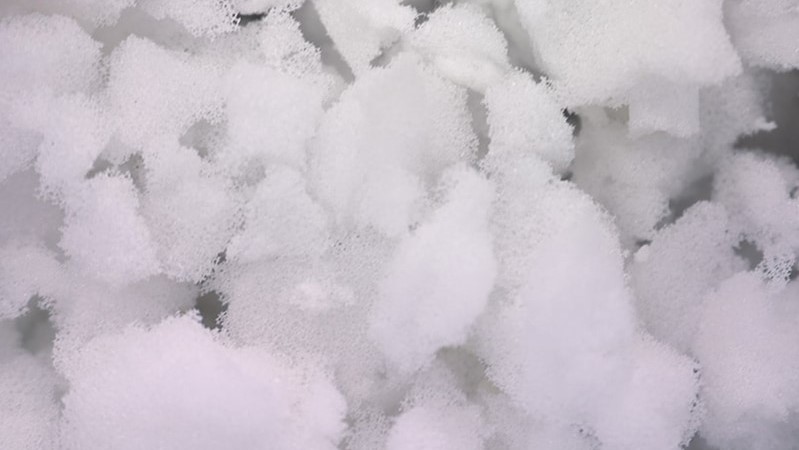 Close-up image of a bunch of white shredded memory foam from a pillow